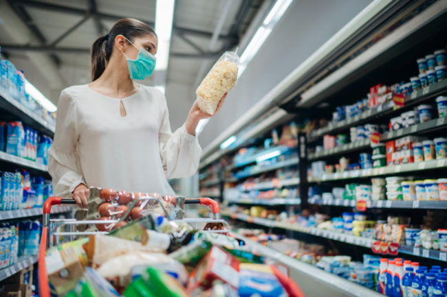 Woman grocery shopping while wearing mask