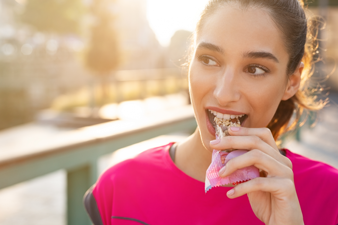 Sporty woman eating energy bar