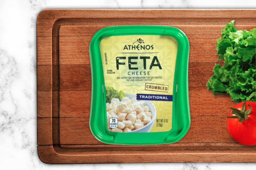 Athenos feta cheese on a cutting board with lettuce and tomato