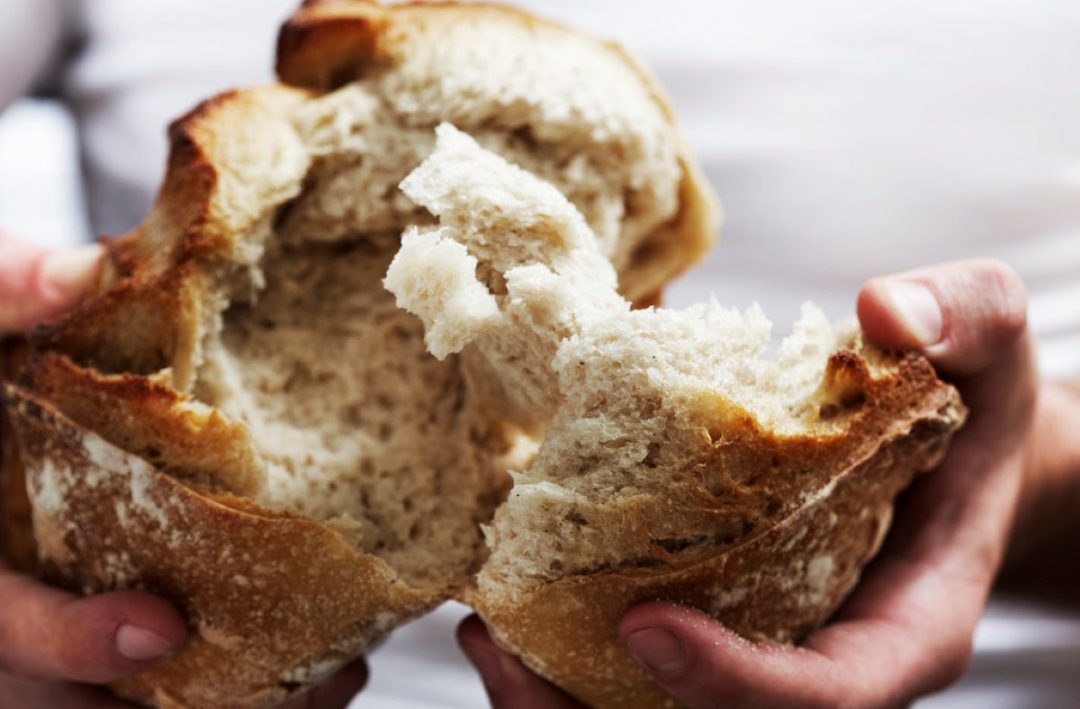 Person breaking bread
