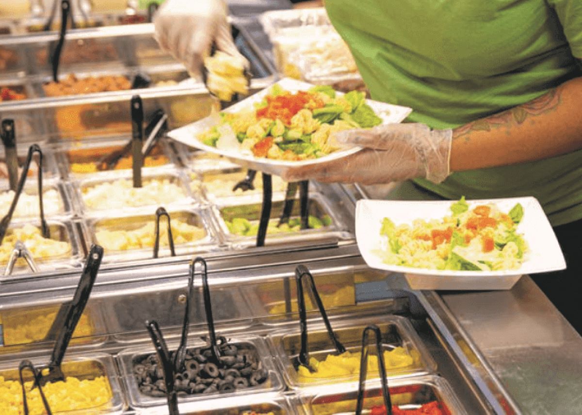employee-preparing-salad-from-salad-bar