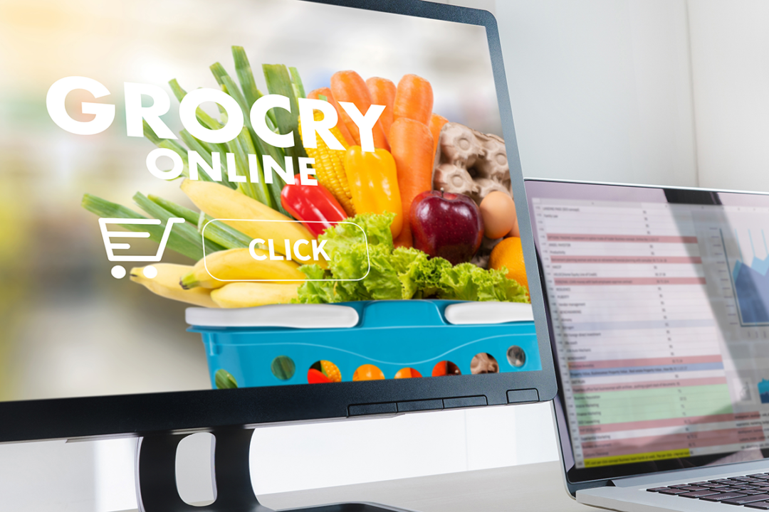 computer monitor that says "grocery online" next to a laptop screen with charts and graphs