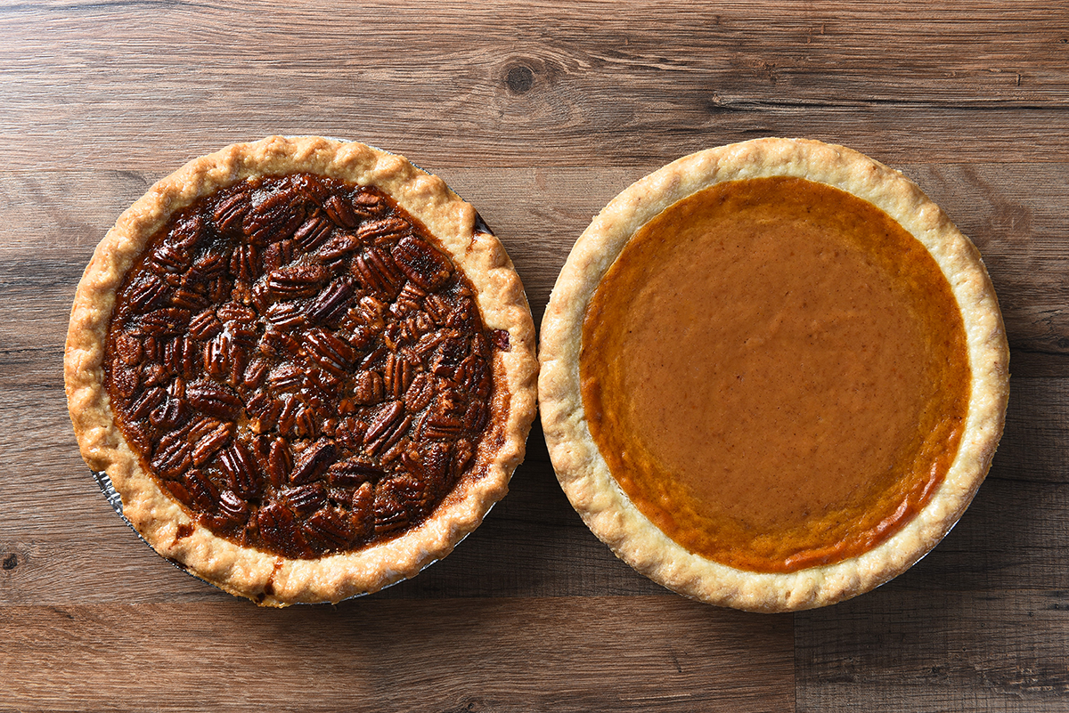 pecon-pie-next-to-pumpkin-pie-on-wooden-surface