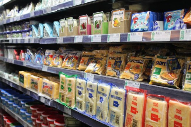 dairy shelves in a supermarket stocked with cheese products