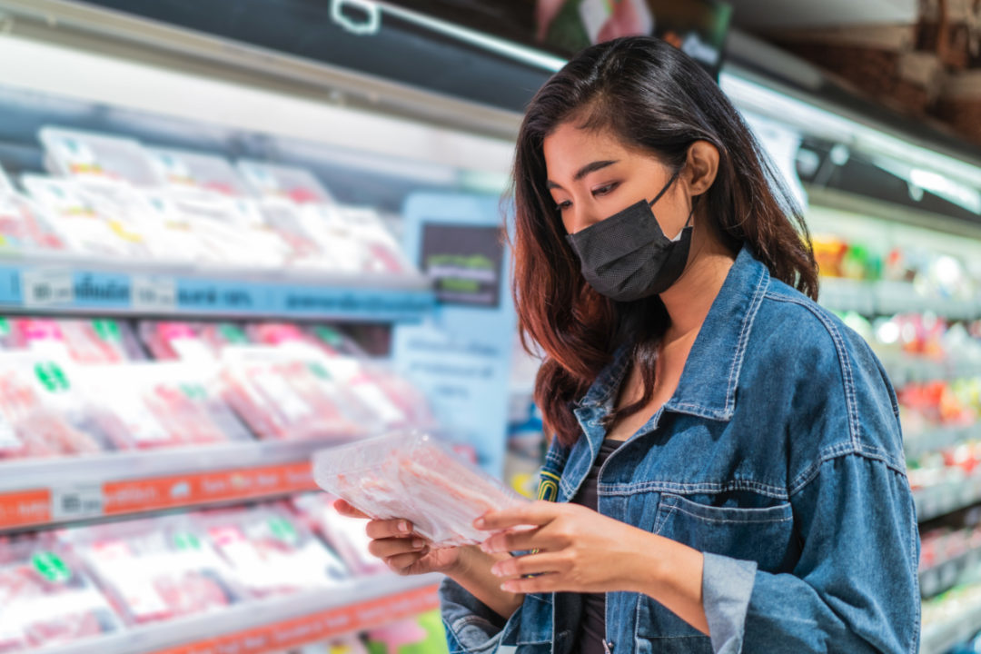 Woman Reading Food Label With Mask