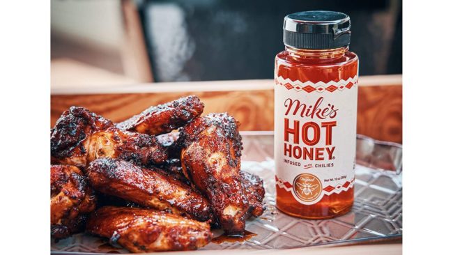 Mike's Hot Honey bottle with chicken wings