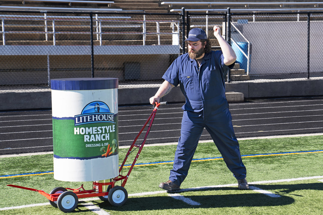 man-painting-football-field-with-litehouse-branded-barrel