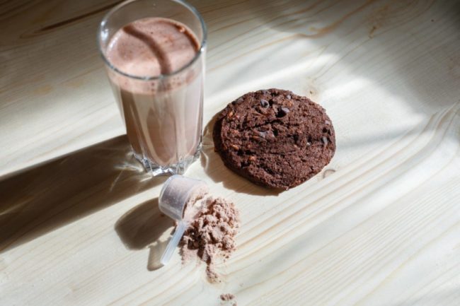 chocolate cookie next to a glass of chocolate milk