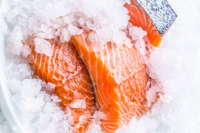 Close-up of fresh raw salmon fillets on ice