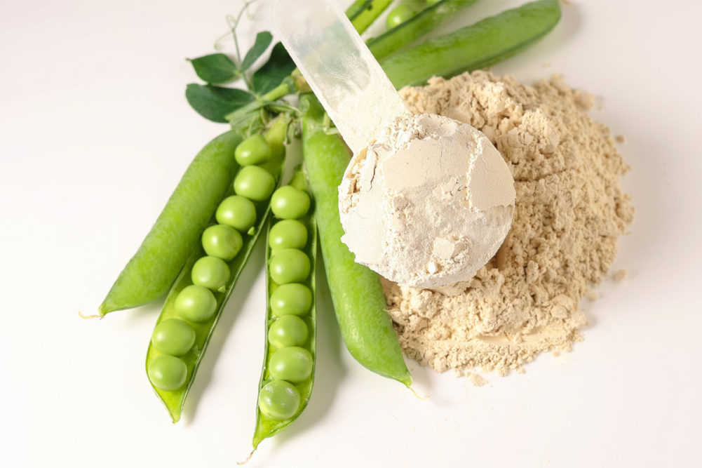 Green peas next to a scoop of protein powder
