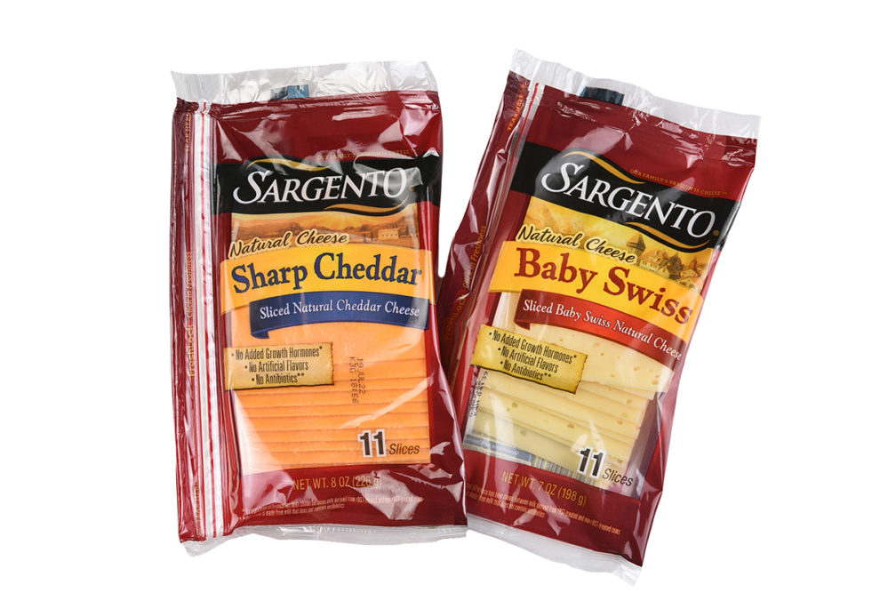 Two packages of Sargento Sliced Cheese, Sharp Cheddar and Baby Swiss.