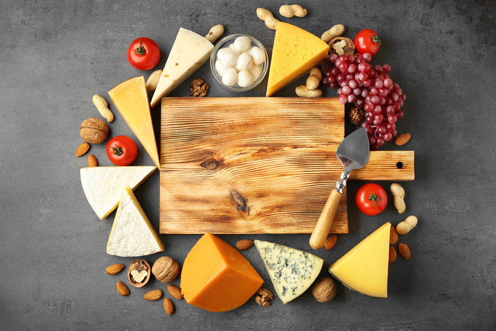 cheeses around a wooden board