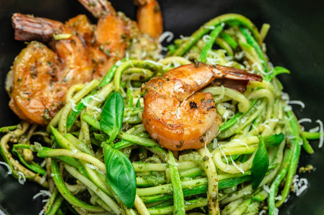 Pasta spaghetti zucchini basil pesto sauce and grilled shrimp, Vegetarian vegetable pasta, Food recipe background. Close up,