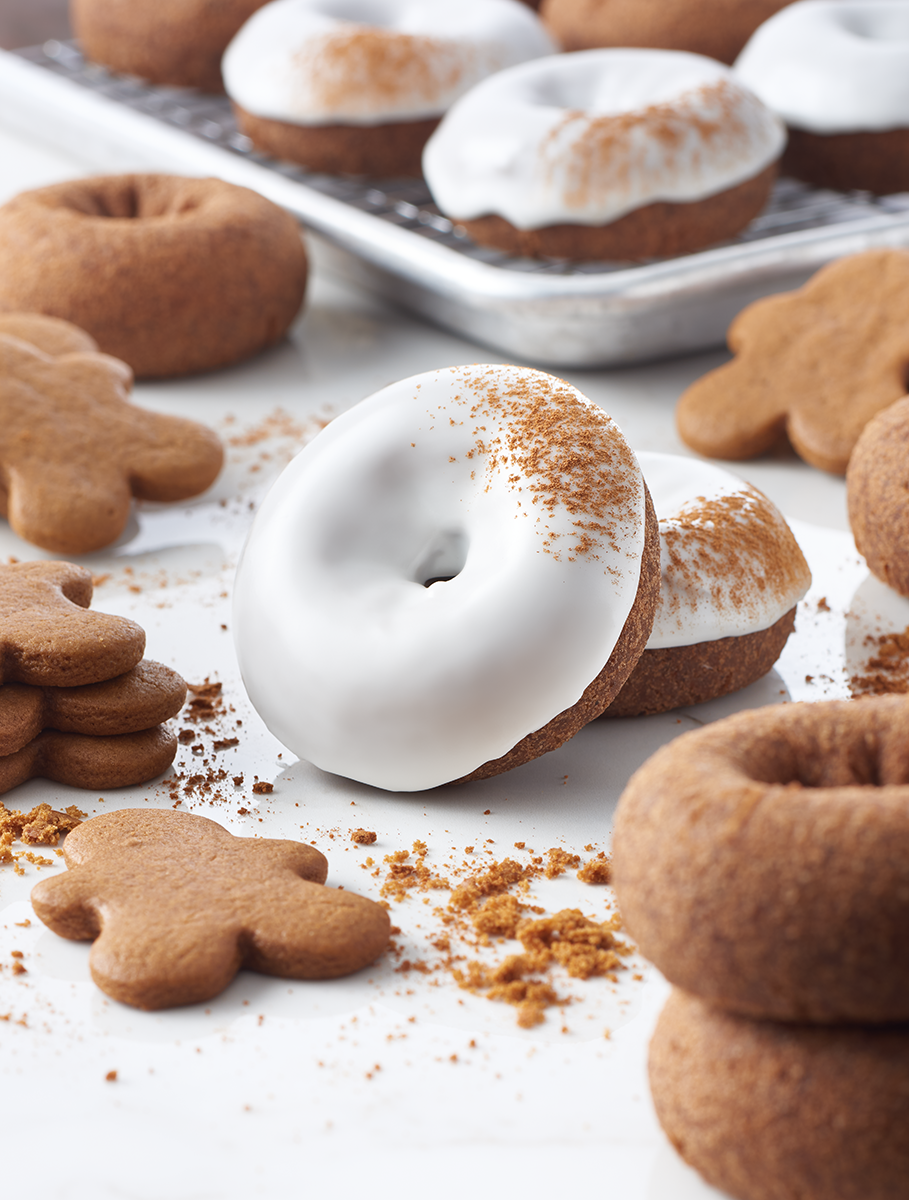 Gingerbread donut on white surface with gingerbread men around it