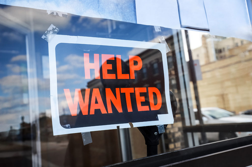 help wanted sign on a glass window