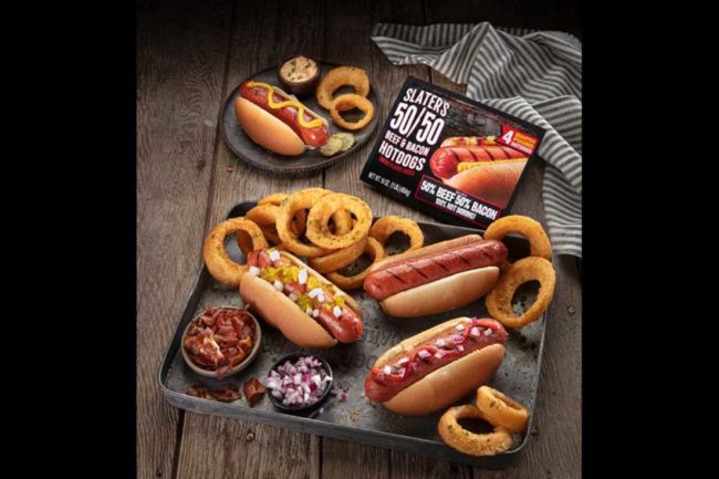 slater's 50/50 hotdogs in packaging next to cooked hotdogs on display