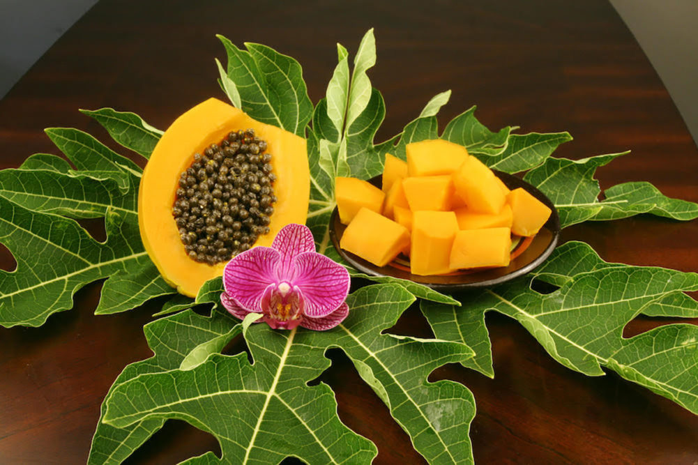 papaya with green leaves and flowers
