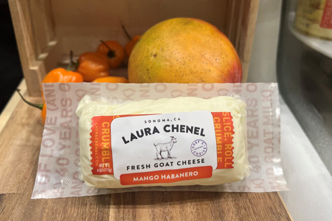 laura chenel mango habanero goat cheese log in packaging on a wooden board