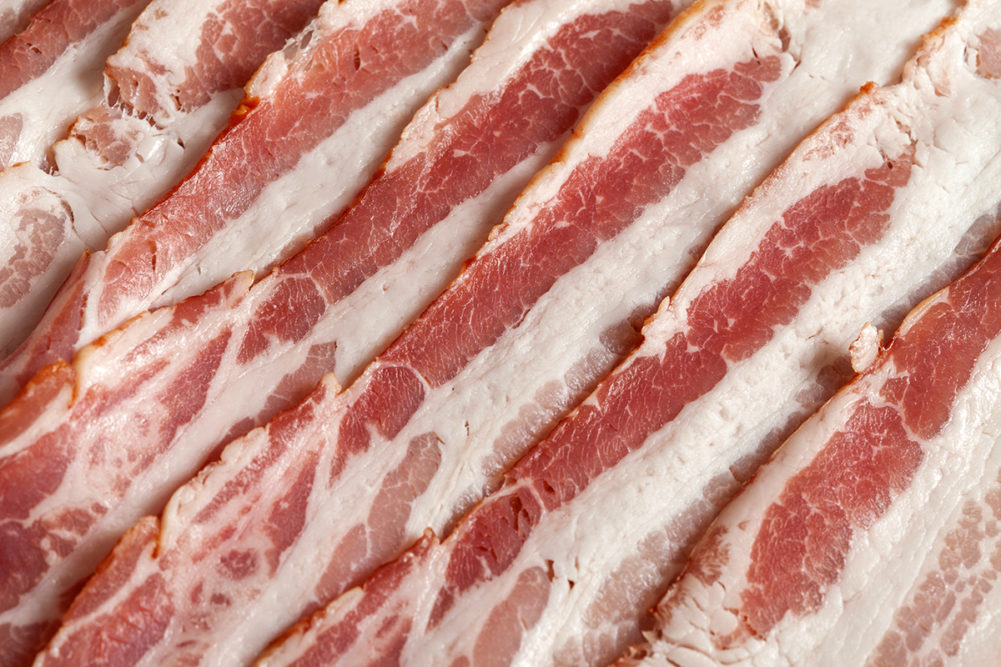 Slices of raw bacon fat over the entire surface.