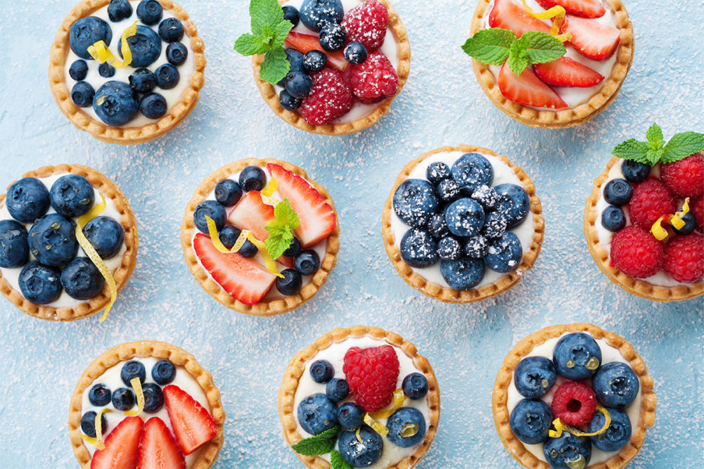 baked tarts with fruit on a blue background