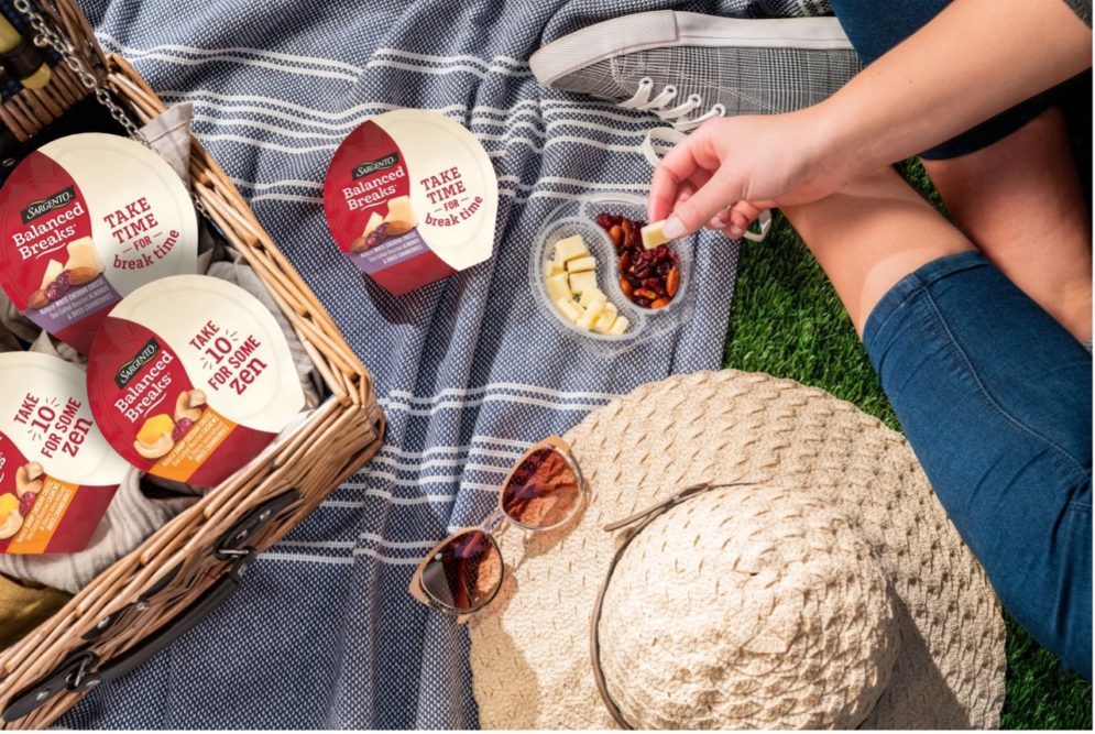 people on a picnic blanket eating Sargento Foods balanced breaks