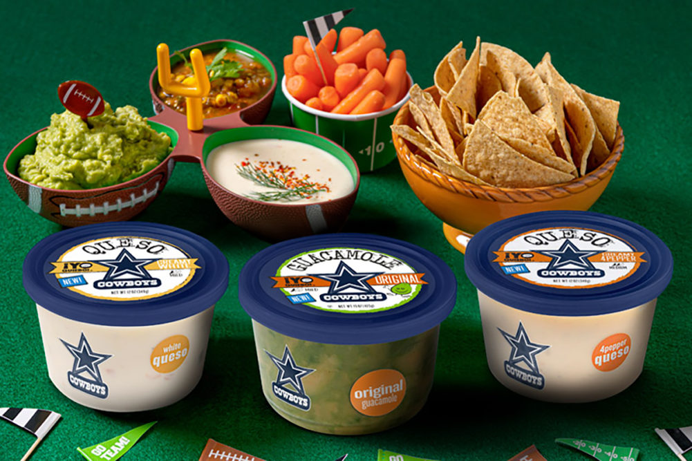 ¡Yo Quiero! containers with Dallas Cowboys logos and bowls of vegetables and chips