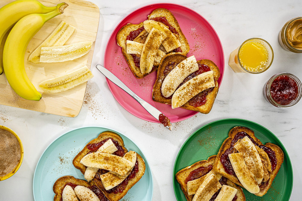 peanut butter banana sandwiches being prepared on colorful plates