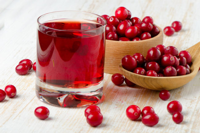 cranberry juice in a glass with cranberries around