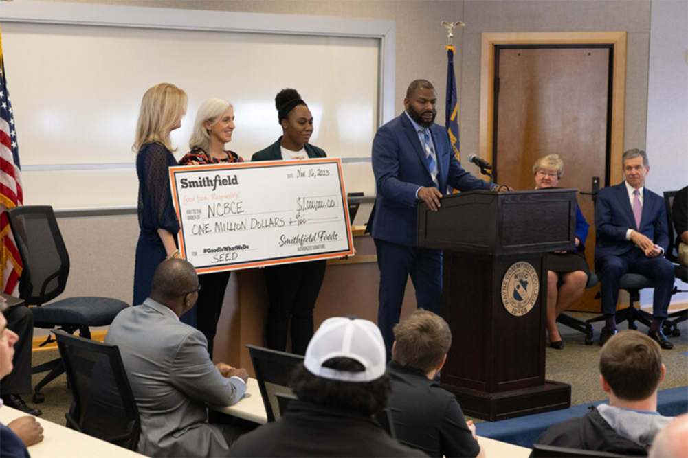 people holding large check at ceremony