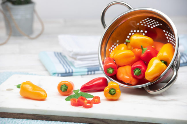 small peppers in a strainer in a kitchen