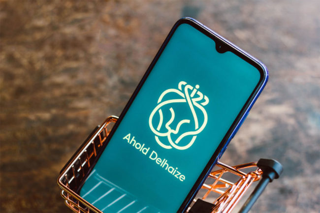 Ahold-Delhaize-Logo-on a smart phone in a mini grocery basket