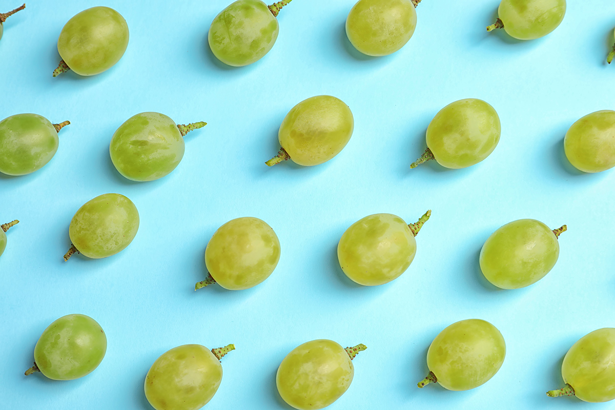 Fresh ripe juicy green grapes on color background, top view